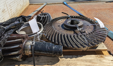 Damaged large industrial spiral bevel gears on a transport pallet, ready for 3D scanning by NE Solution.